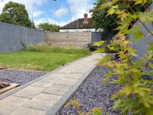 a garden with a sidewalk and a fence at Llantarnam House by Tŷ SA in Cardiff