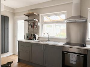 a kitchen with a sink and a counter top at Llantarnam House by Tŷ SA in Cardiff
