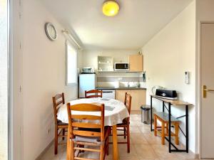 a kitchen and dining room with a table and chairs at La cachette du Mas, 4 pers Piscine à Calvisson in Calvisson