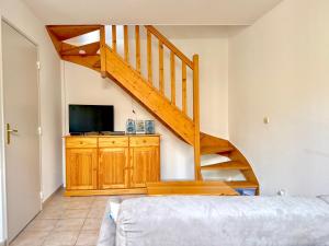 a bedroom with a staircase with a television and a bed at La cachette du Mas, 4 pers Piscine à Calvisson in Calvisson