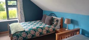 a bedroom with a bed with a blue wall at Lakeview in Fenagh