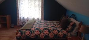 a bedroom with a bed with a flowered blanket and a window at Lakeview in Fenagh +8 photos