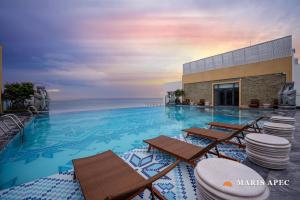 a large swimming pool with chairs and the ocean at Maris Apec Tuy Hoà in Tuy Hoa