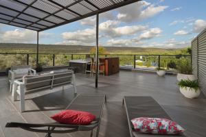 a patio with chairs and a table with a view at קולינה וארדה in ‘Amqa