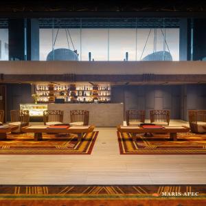 a dining room with tables and chairs and windows at Maris Apec Tuy Hoà in Tuy Hoa