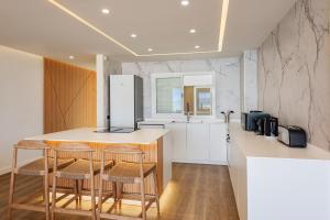 a kitchen with a island with stools and a refrigerator at Apartment Vistamar II in Port de Pollensa +7 photos