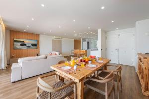 a kitchen and living room with a wooden table and chairs at Apartment Vistamar II in Port de Pollensa