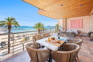 a patio with a table and chairs and a view of the beach at Apartment Vistamar II in Port de Pollensa