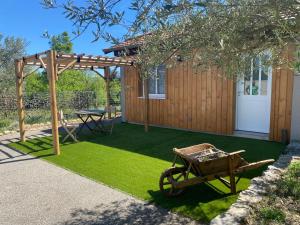 a garden with a picnic table and a wooden pergola at Chambre Ephédra in Sampzon