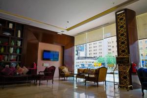 a lobby with chairs and a table and a large window at Al Muhaidb Al Olaya Suites - Economic in Riyadh