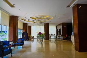 a lobby with blue chairs and a table with flowers at Al Muhaidb Al Olaya Suites - Economic in Riyadh