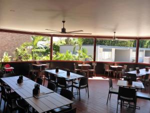 a restaurant with tables and chairs and windows at The Commercial Hotel Motel in Chinchilla