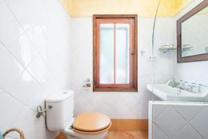 a white bathroom with a toilet and a sink at Casita Sa Calobra in Cala Tuent +17 photos