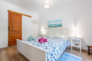 a bedroom with a bed with a blue and white comforter at Casita Sa Calobra in Cala Tuent