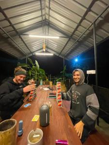 two men sitting at a wooden table at FREEDOM HOUSE, Munnar - A Backpackers Hostel in Munnar +60 photos