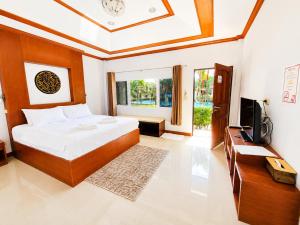 a bedroom with a bed and a television in it at Phuket Airport Villa in Phuket