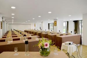 a room full of tables and chairs with a vase of flowers at Airotel Achaia Beach in Patra +101 photos
