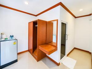 a kitchen with a wooden cabinet next to a refrigerator at Phuket Airport Villa in Phuket