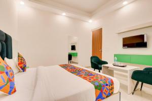 a hotel room with a bed and a desk and a television at Hotel Paradise Palace in Ghaziabad