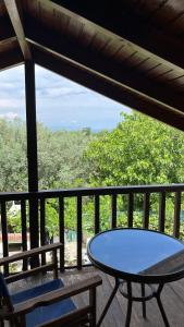 a table and chairs on a deck with a view of trees at Azure Escape Villa in Platamonas