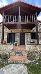 a stone house with a large wooden deck at Azure Escape Villa in Platamonas