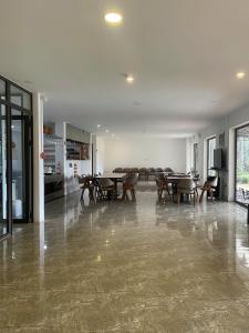 a dining room with tables and chairs in a room at Mimosa Forest Hotel Villa in Xuan An