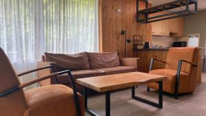 a living room with a couch and a table at De Zandzegge | 4 persons in Gasselte +22 photos
