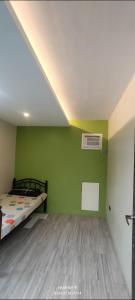 a bedroom with a bed and a green wall at Gerry's Place in Iloilo City +2 photos