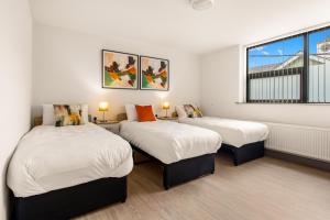 a room with two beds and a window at Clanbrassil Townhouse in Dundalk