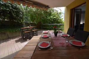 a wooden table with plates of food on a patio at Apart Holidays - Residenza Flora in Locarno