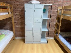 a room with two bunk beds and a white locker at Hostel da Maria - Porto in Vila Nova de Gaia