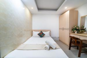 a small bedroom with a bed and a desk at Ngân Hà Bouitque Apartment-Hotel in Ho Chi Minh City