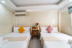 two beds with colorful pillows in a room at Ngân Hà Bouitque Apartment-Hotel in Ho Chi Minh City