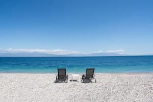 two chairs and a table on the beach at Villa Dorianna in Egira