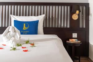 a bed with a blue pillow and a stuffed animal on it at D'Lioro Hotel & Resort in Ha Long