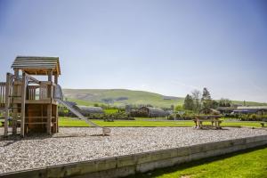 a playground with a slide and a bench in a park at Sunflower in Saint Harmon