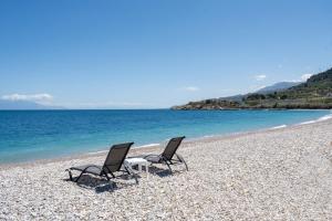 two chairs and a table on a beach at Villa Dorianna in Egira +30 photos