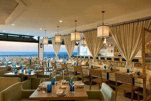 a restaurant with tables and chairs and the ocean in the background at Ashore Oceanfront Hotel by Marriott in Ocean City