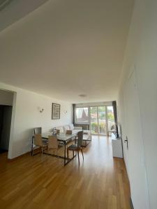 a dining room and living room with a table and chairs at Appartement entier Velodrome in Roubaix