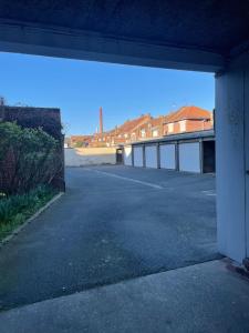an empty parking lot with a building in the background at Appartement entier Velodrome in Roubaix