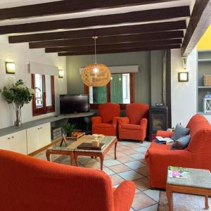 a living room with red chairs and a table at LEON DORMIDO Rooms & Apartments in Polop