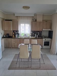 a kitchen with a glass table and chairs at Nana apartment in Perea