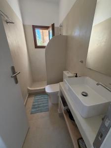 a bathroom with a sink and a toilet and a mirror at Patmian charm 2 bedrooms in Skala