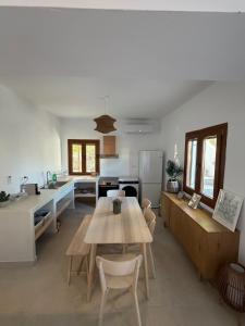 a kitchen and dining room with a wooden table and chairs at Patmian charm 2 bedrooms in Skala