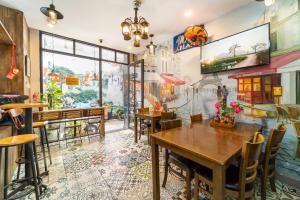 a restaurant with tables and chairs and a mural on the wall at Ngân Hà Bouitque Apartment-Hotel in Ho Chi Minh City