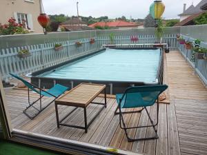 a swimming pool with two chairs and a table on a deck at la passerelle in Maurs