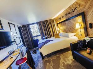 a hotel room with a large bed and a couch at ibis Styles Douai Gare Gayant Expo in Douai +90 photos
