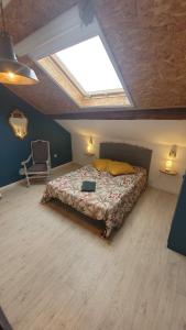 a bedroom with a large bed with a skylight at Gîtes & Chambres d'hôtes Villa La Lorraine in Folkling