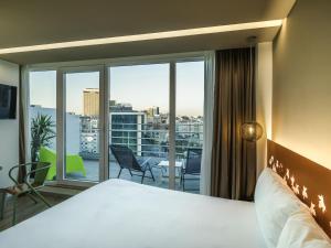 a hotel room with a bed and a large window at Ibis Styles Lisboa Centro Marquês de Pombal in Lisbon