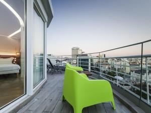 a balcony with green chairs and a view of the city at Ibis Styles Lisboa Centro Marquês de Pombal in Lisbon
